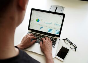 Man at laptop reviewing data and typing